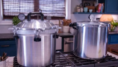 Two pressure canners with dial gauges on a kitchen stovetop