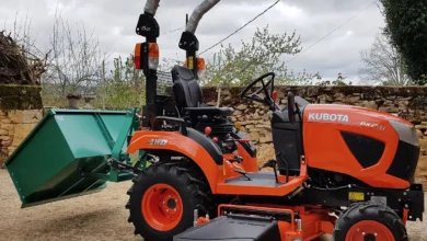 Orange Kubota BX sub-compact tractor with a mid-mount mower and a rear tipping box